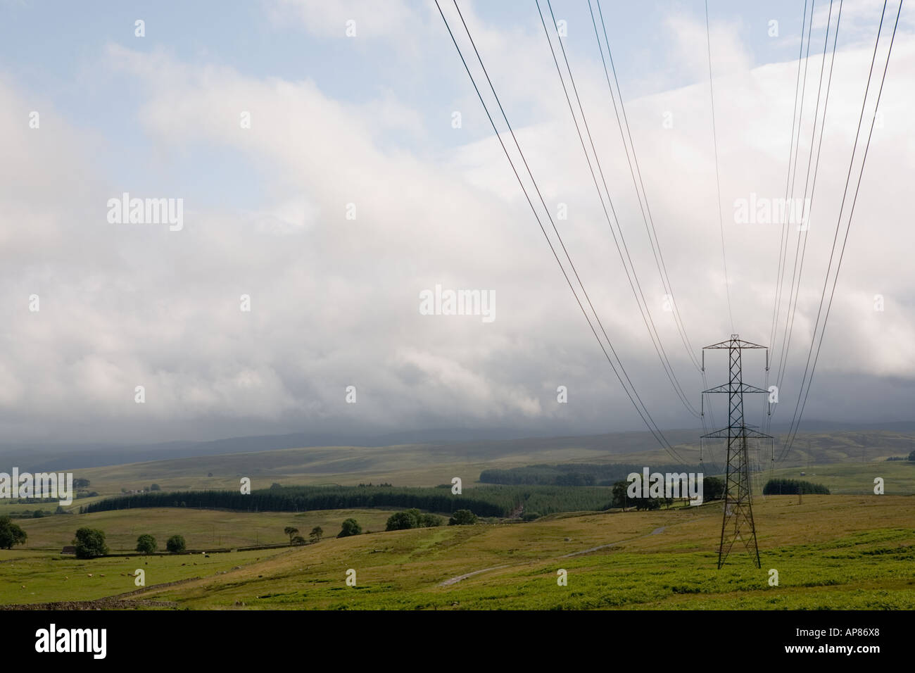 Electricity pylons against brooding sky, Lakeland fells, Cumbria, England Stock Photo