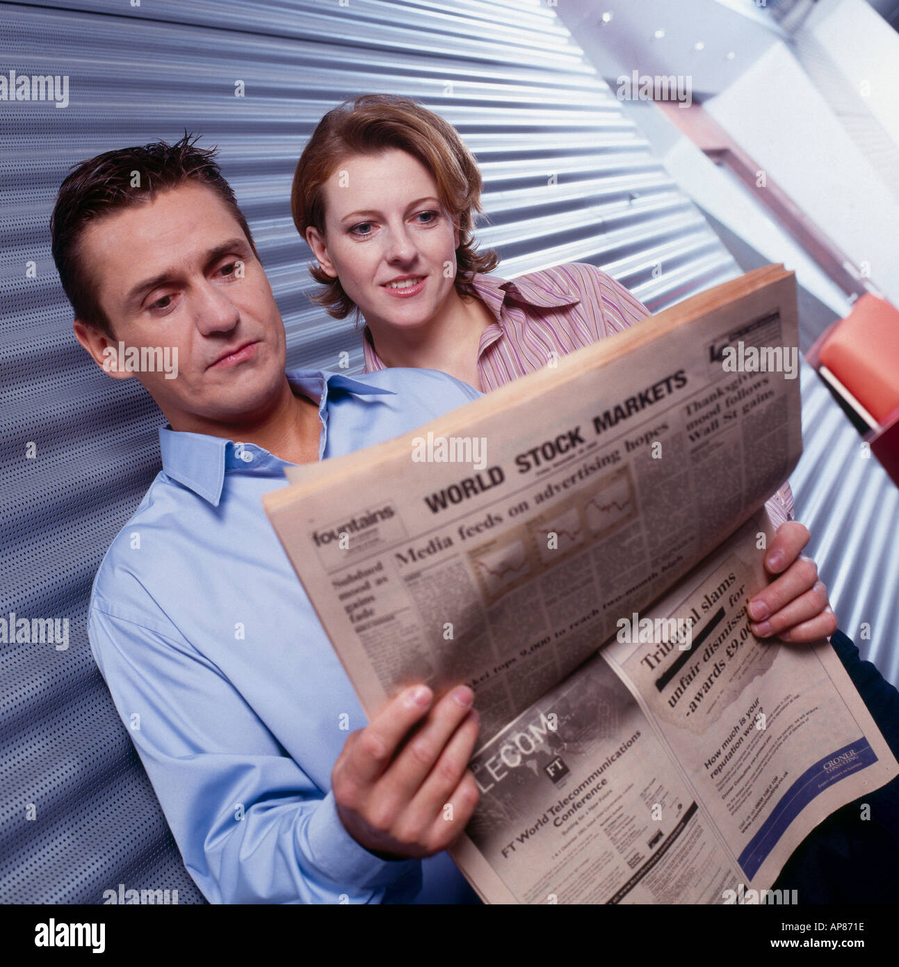 Two employees reading a newspaper Stock Photo