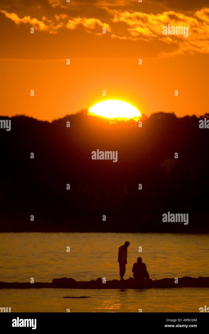 Sunset with 2 figures on sandbar, Compo Beach, Westport, Ct, USA. Stock Photo