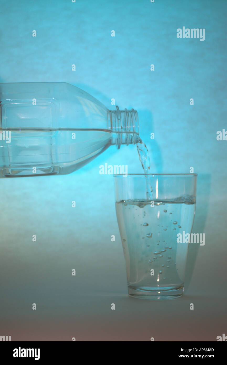 a glass and bottle of refreshing mineral water with ice cubes Stock ...