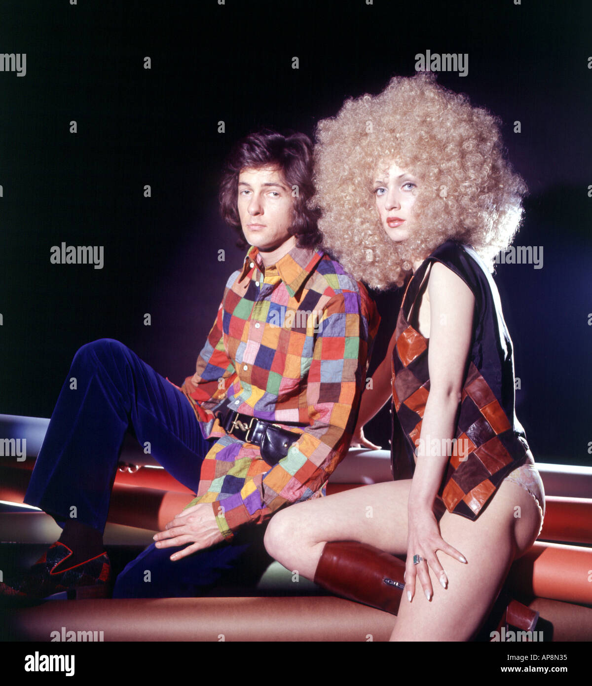1970s couple posing in patchwork outfits Stock Photo
