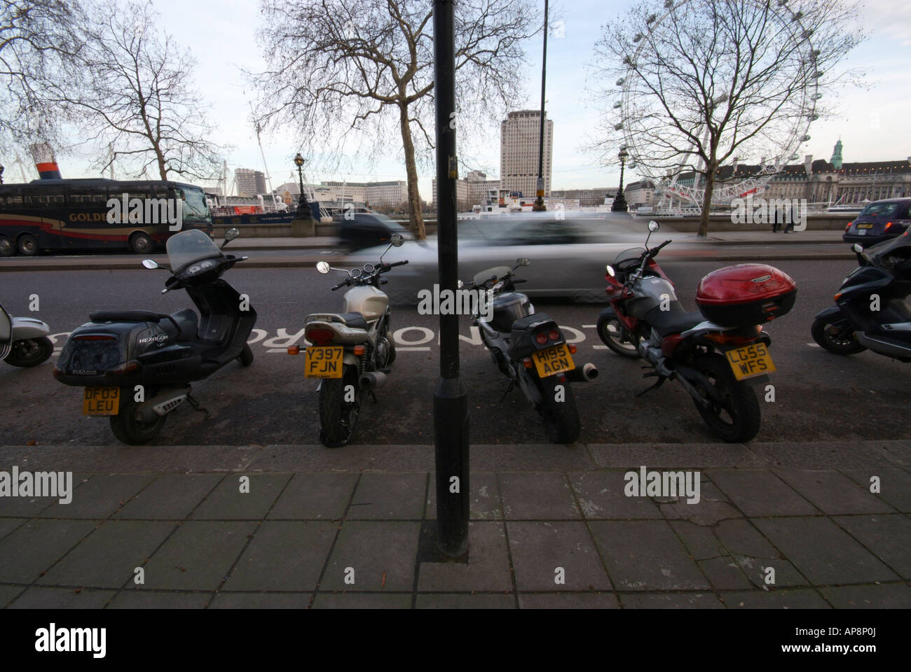 Motorbikes parked in the road in parking bays. Stock Photo