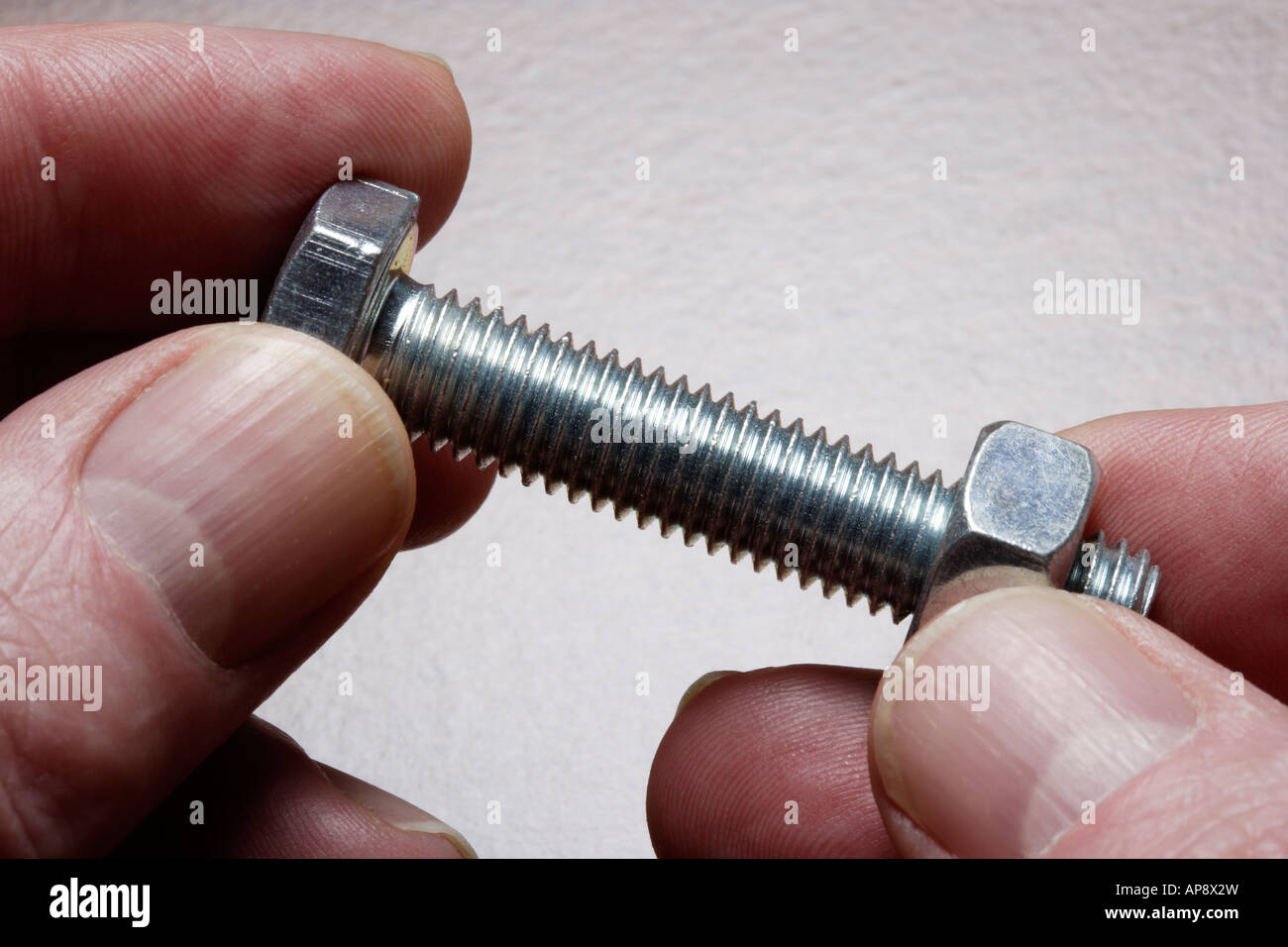 Man fitting nut to bolt close-up Stock Photo