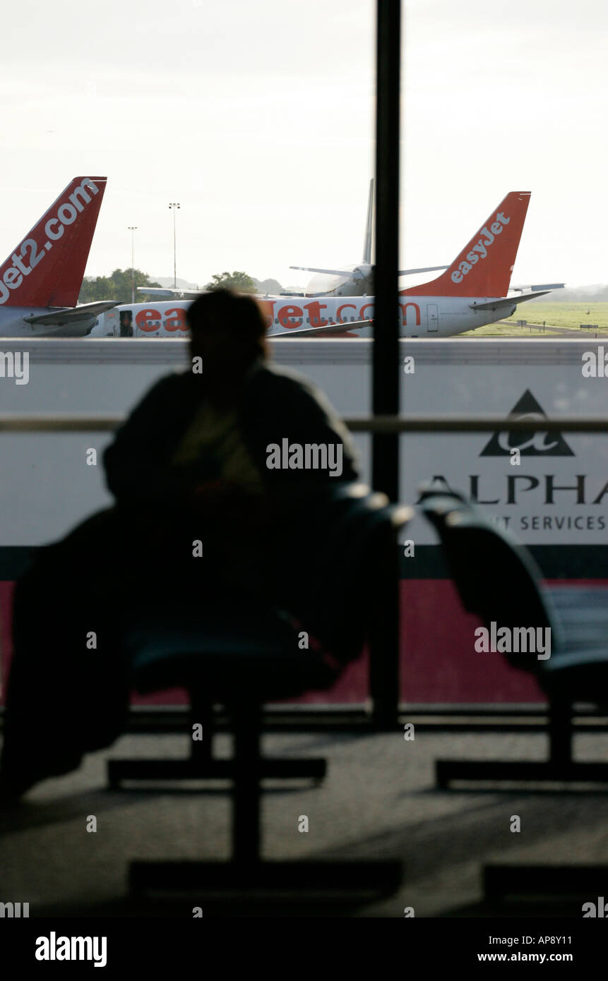 Passenger waiting in lounge in front of window at Belfast International airport northern ireland Stock Photo