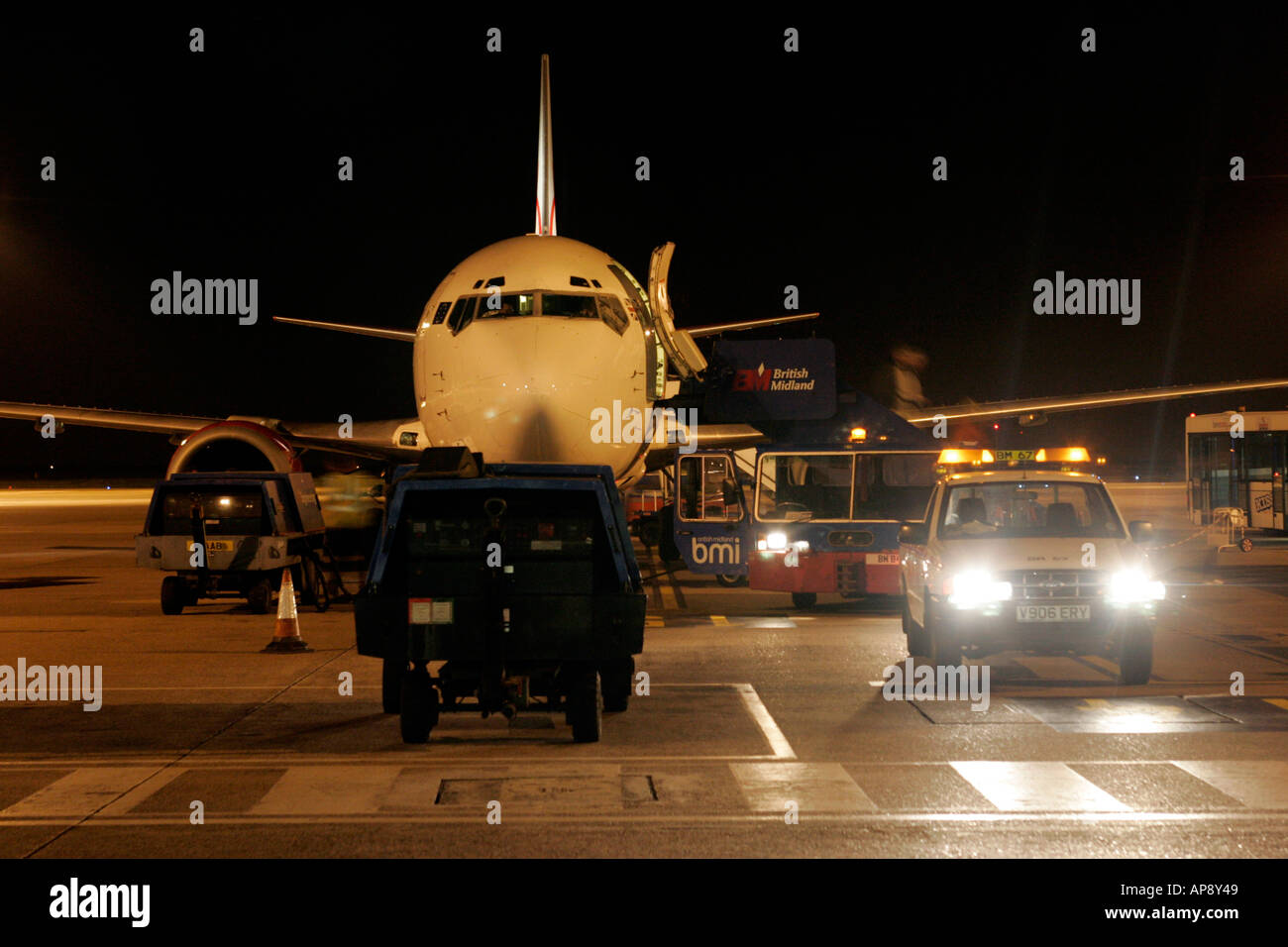 Passengers disembarking and plane unloading BMI baby boeing 737 aircraft at night nottingham east midlands airport england Stock Photo