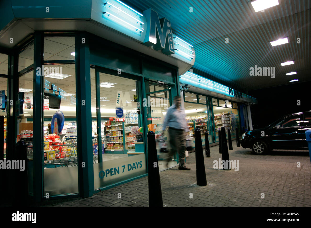 Mace shopping market in a petrol station garage forecourt at night with customer leaving northern ireland Stock Photo