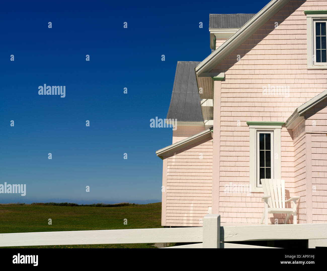 Canada Quebec Gaspesie Riviere la Madeleine pink house and with white fence Stock Photo