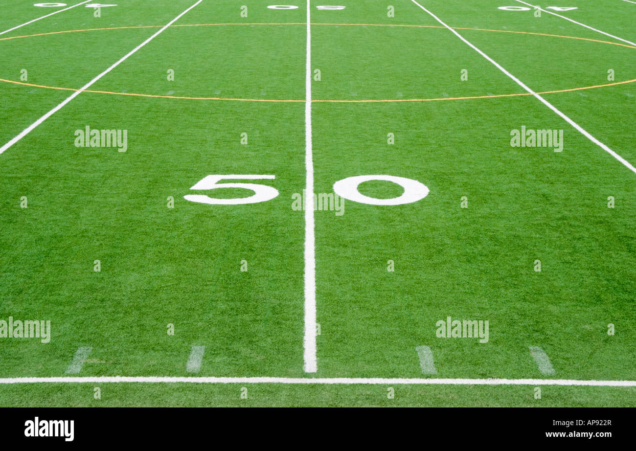 American football field fifty yard line at a sports stadium in the USA, white chalk lines freshly done in five yard increments. Stock Photo