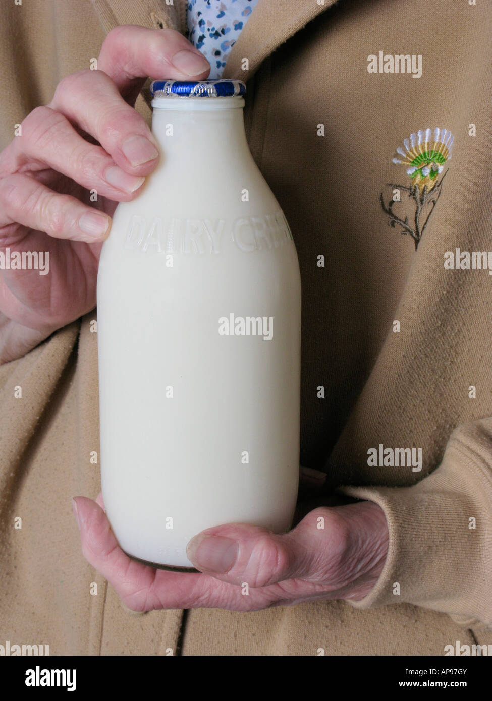elderly woman holding a bottle of Dairy Crest milk, a drink important for the post menopausal woman Stock Photo