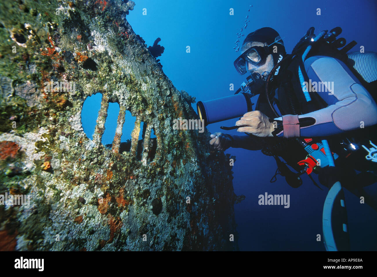 scuba diver shines a light on broadside of the Jabeda wreck Stock Photo