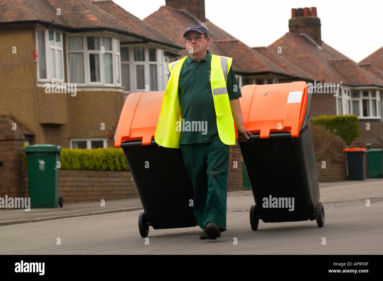 Council workers deliver orange top wheelie bins to city residents for