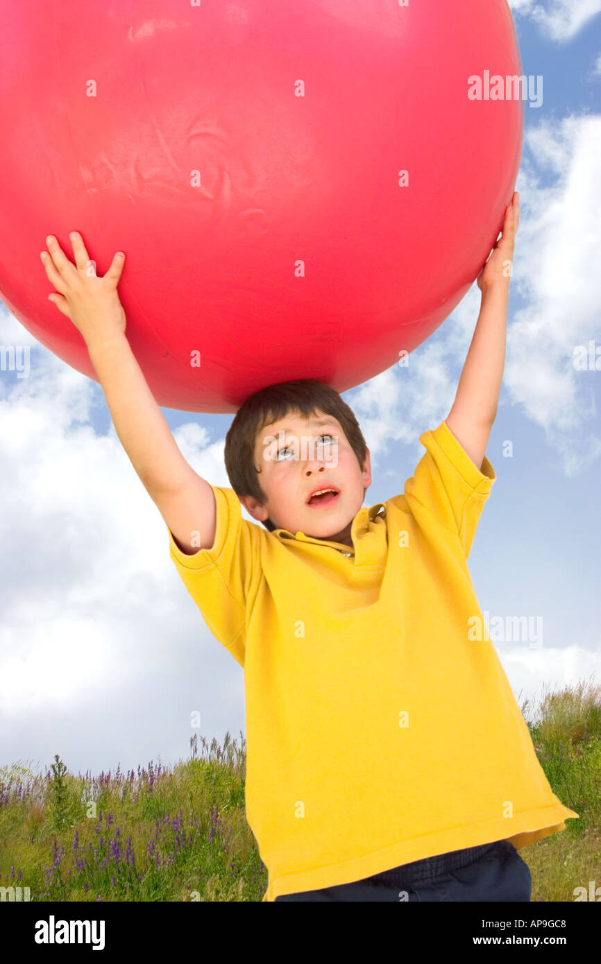 A Young Boy In A Yellow Shirt Holds A Huge Red Ball Over His Head Stock Photo Alamy A Young Boy In A Yellow Shirt Holds A Huge Red Ball Over His Head Stock Photo Alamy