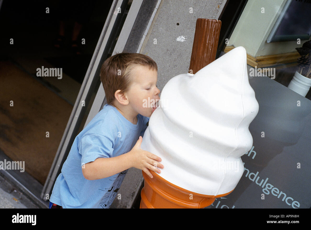 a young boy licks a giant model of an ice cream Stock Photo Alamy