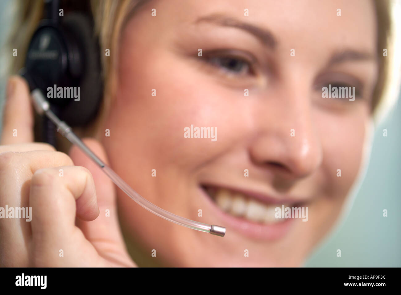 Woman using telephone headset, smiling Stock Photo