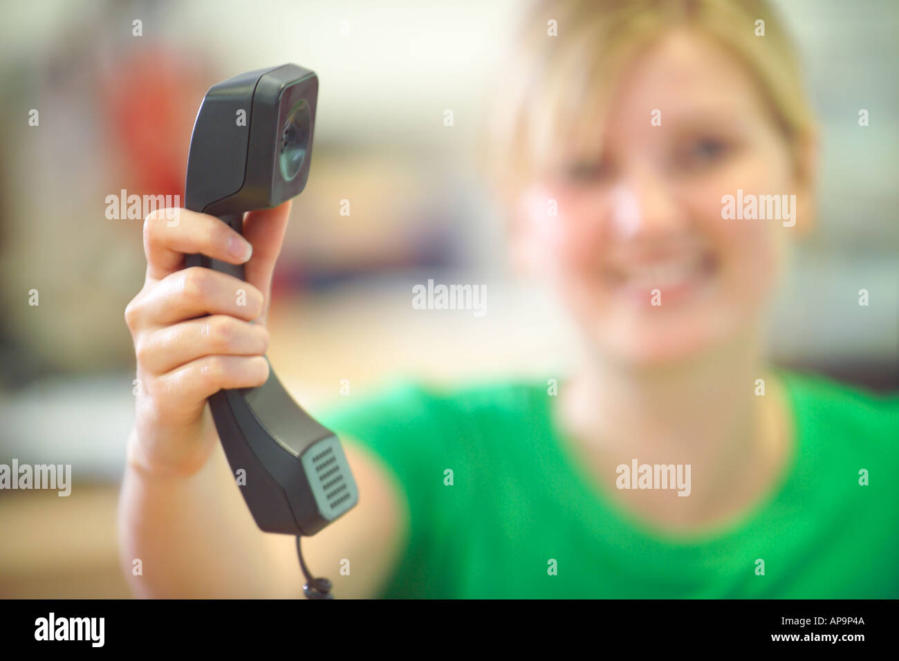 Woman passing telephone receiver in office Stock Photo Alamy
