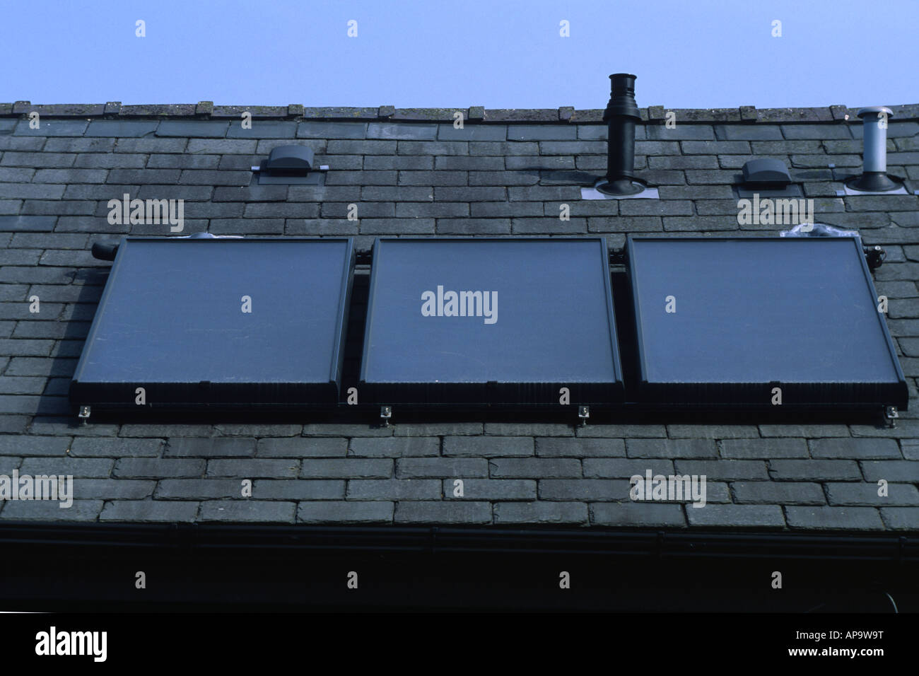 Solar water heating panels on a house roof. Powys, Wales, UK. Stock Photo