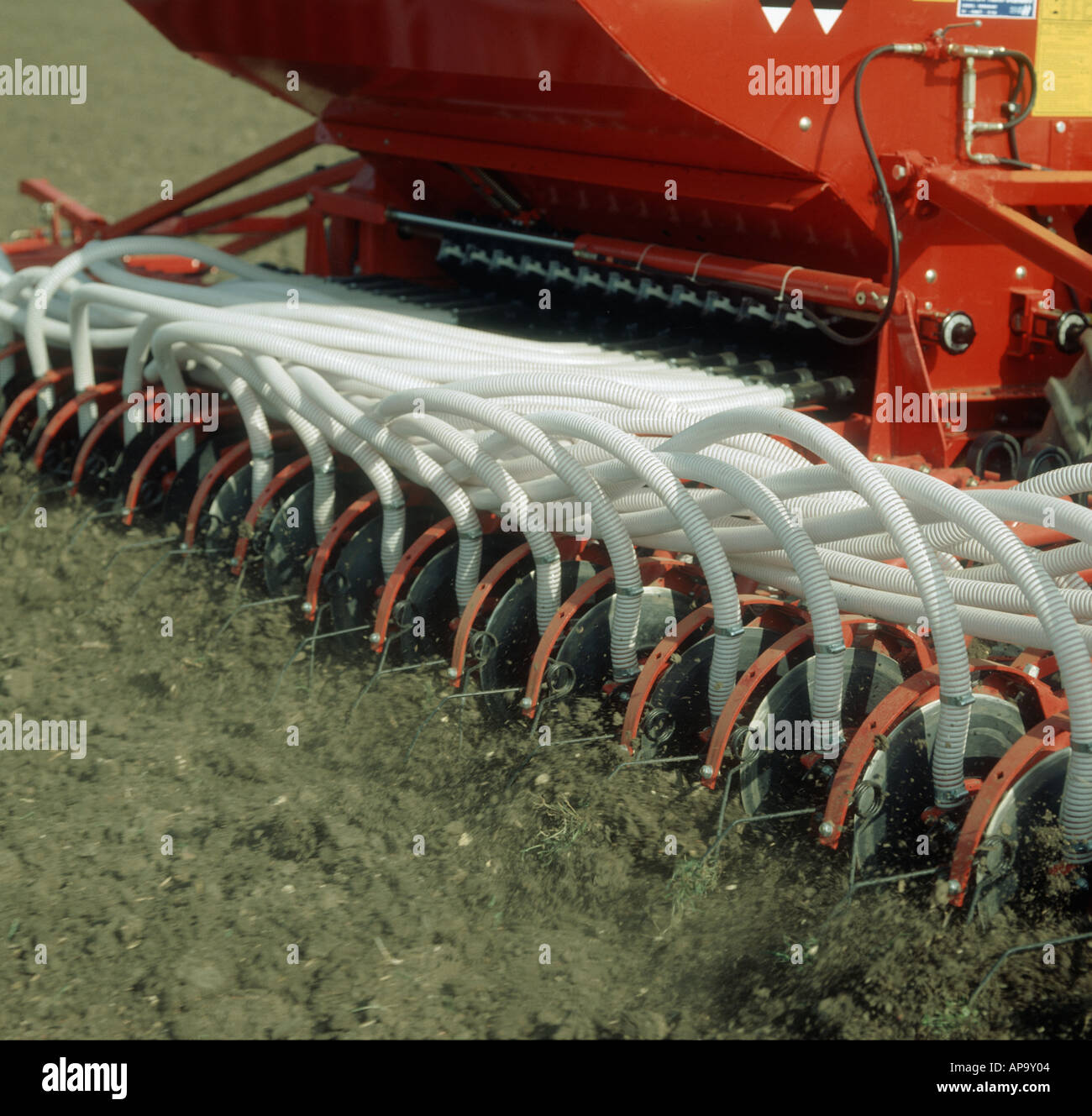 Rear end of a Massey Ferguson pneumatic seed drill planting a cereal crop Stock Photo