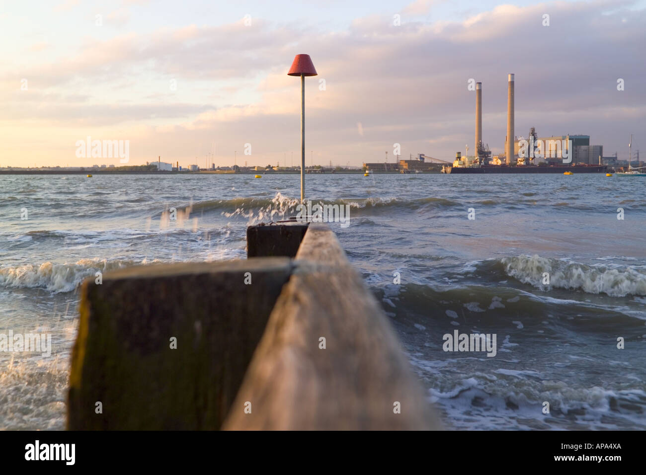Breakwater on the Thames bank at gravesend, with Tilbury power station in background which was demolished in 2019 Stock Photo