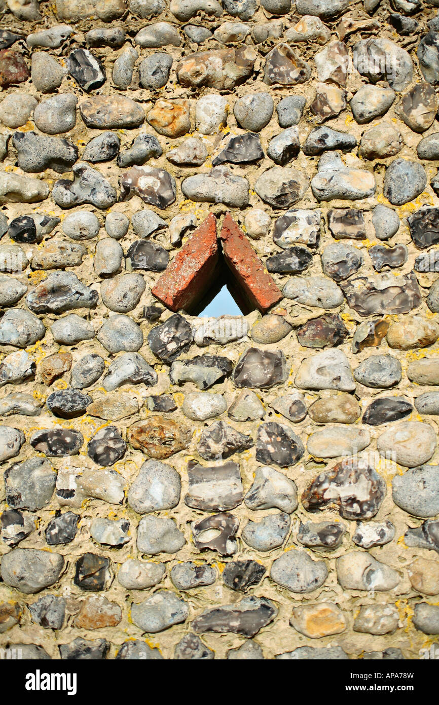 Small triangular opening in a traditional Sussex flint wall Stock Photo