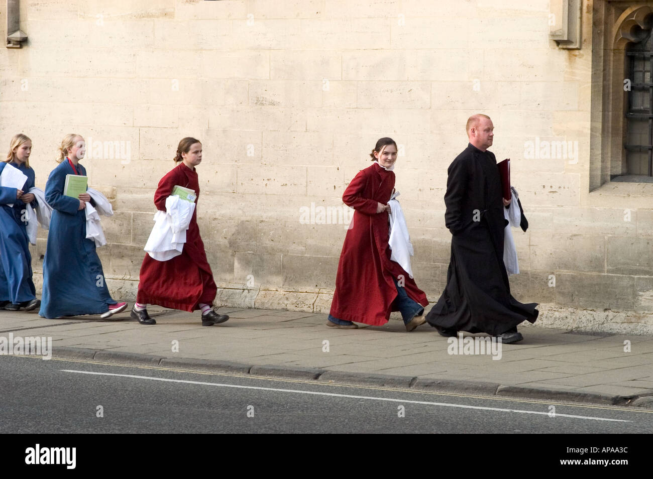 Choir boys and girls walking past Magdalen college Oxford preparing for