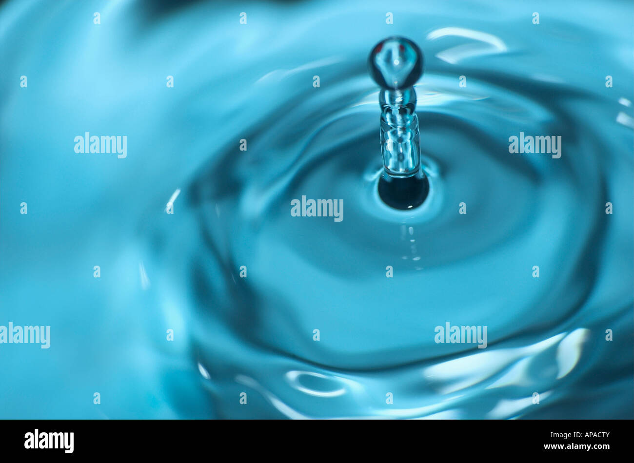 Water droplet splashing against surface of water close up Stock Photo ...