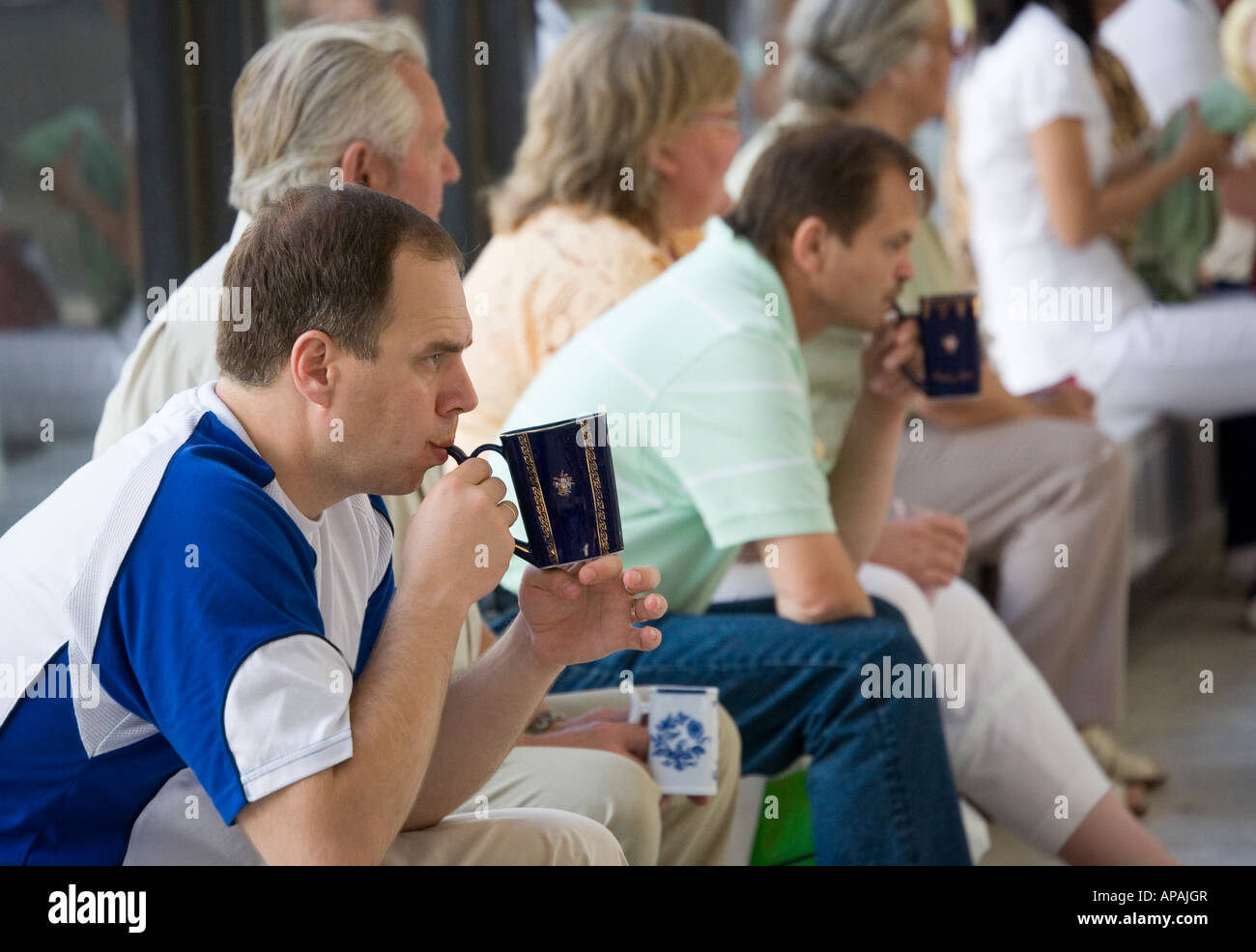 People drinking from traditional becher cups at Vridlo spring no 1 Karlovy Vary Czech Republic Stock Photo