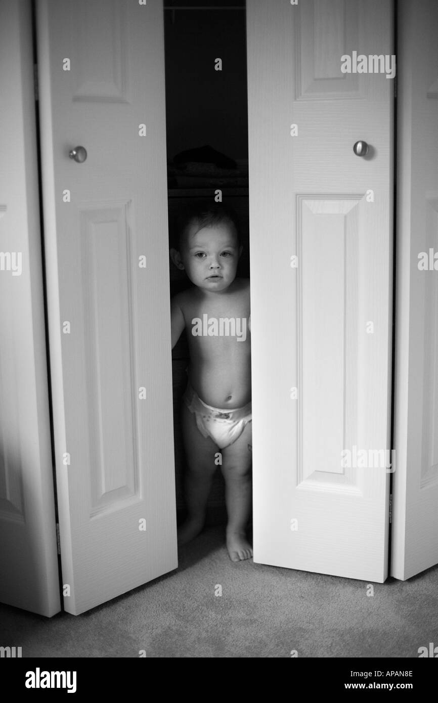 Toddler hiding in closet Stock Photo Alamy