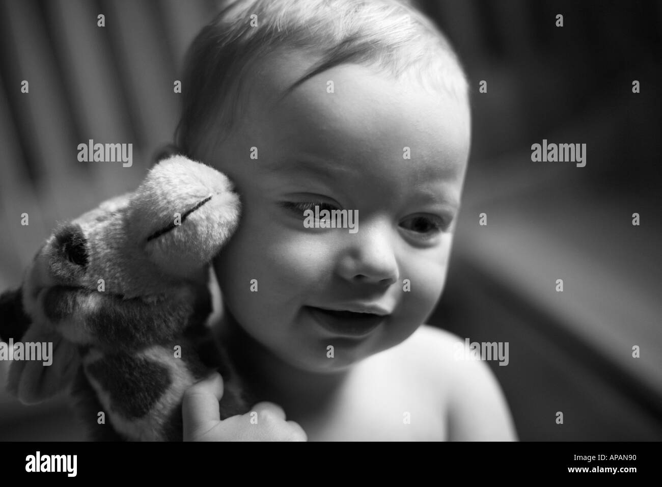 Toddler holding stuffed animal toy tight Stock Photo