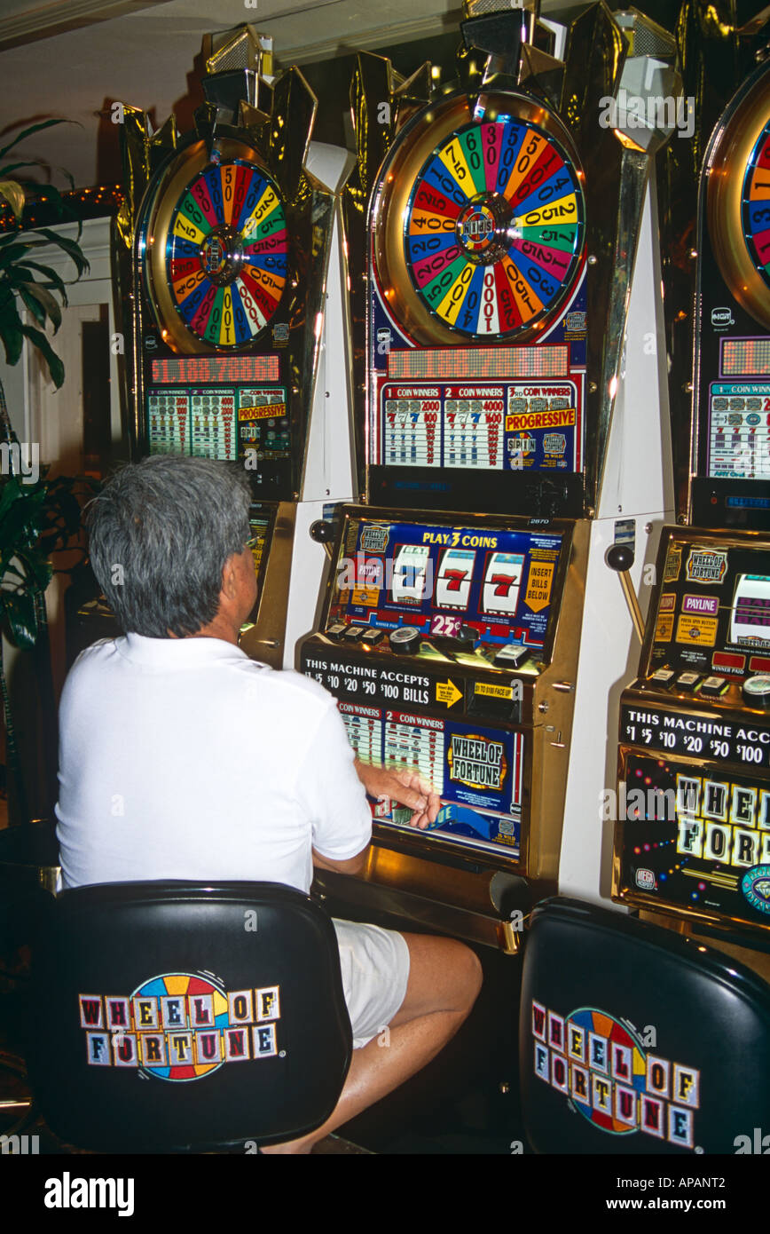 Man playing wheel of fortune slot machine in a casino las vegas
