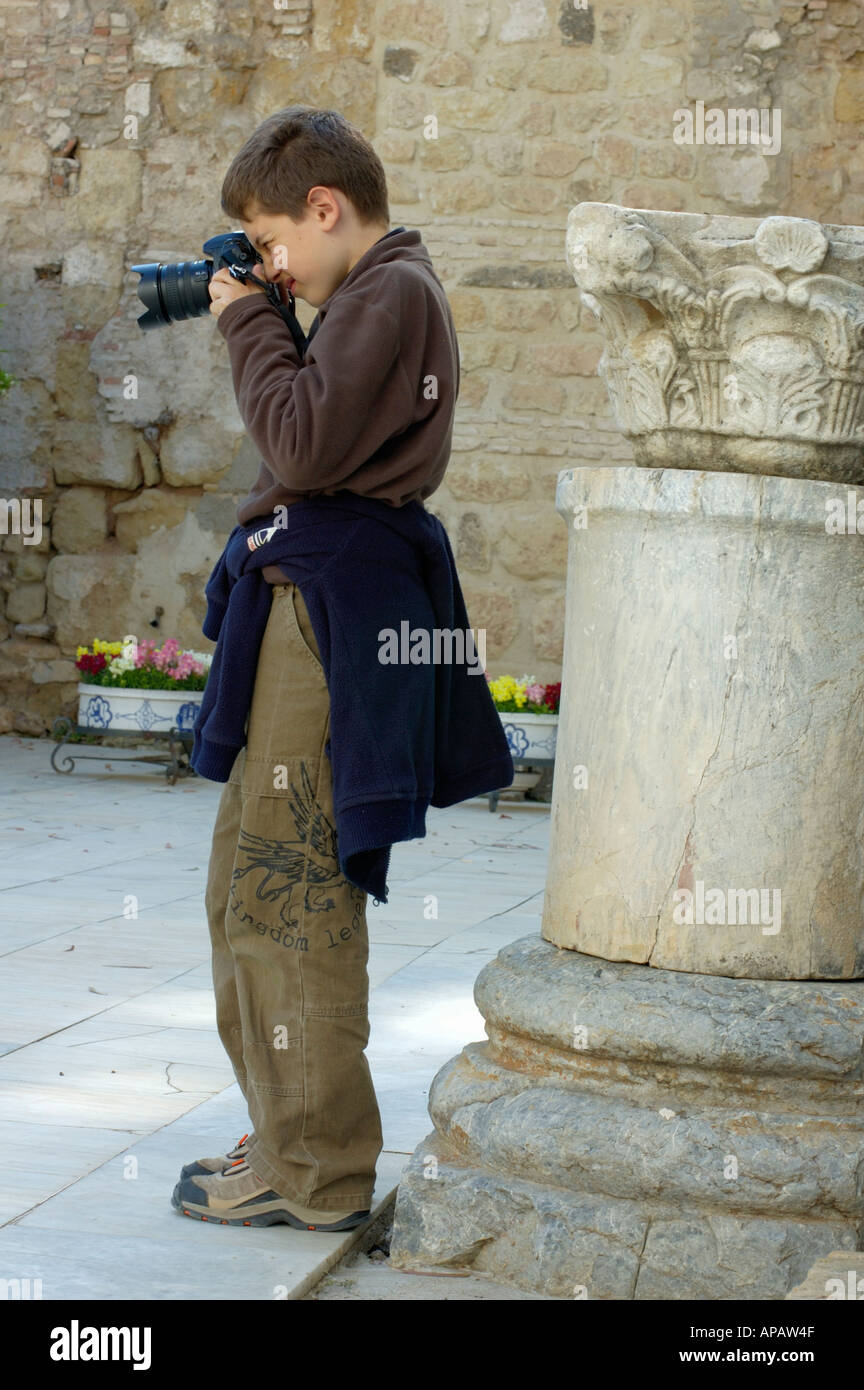 Young boy taking a photograph in the grounds of the Alcazar de los Reyes Cristianos, a medieval palace in Cordoba, Spain. Stock Photo