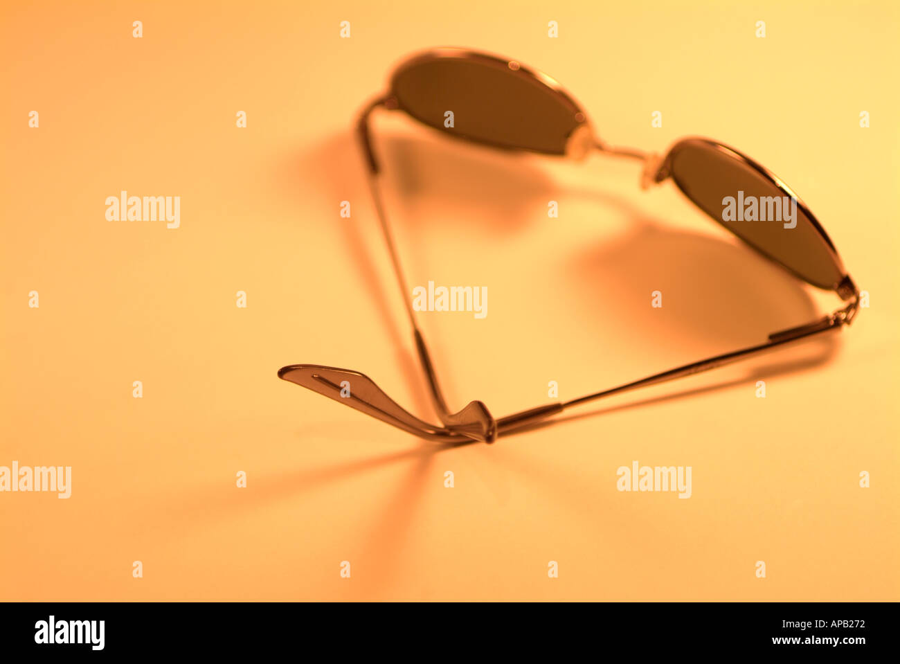 Pair of Sunglasses on an Orange Background Stock Photo