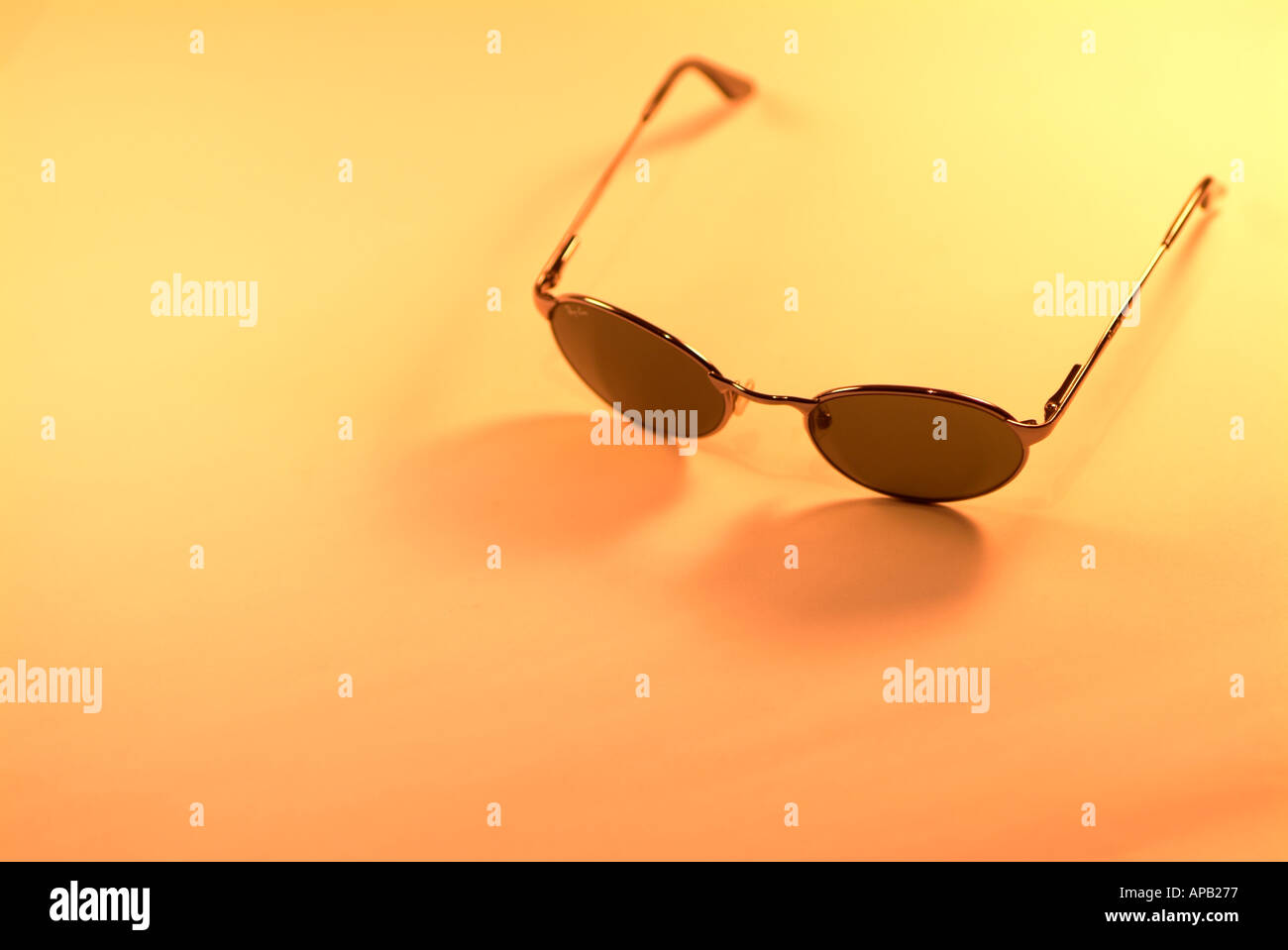 Pair of Sunglasses Against an Orange Background Stock Photo
