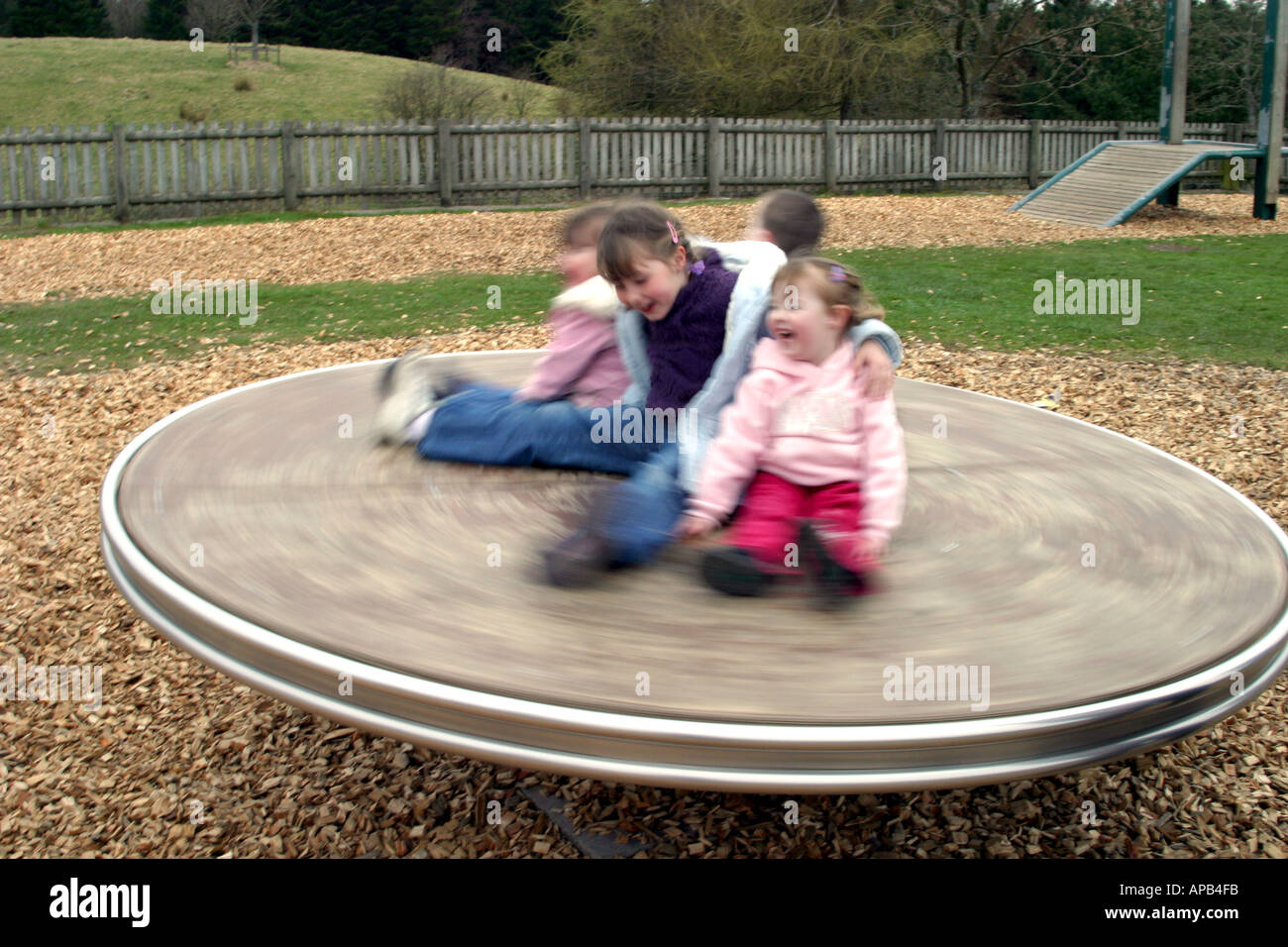 Group of children spinning on roundabout Stock Photo Alamy