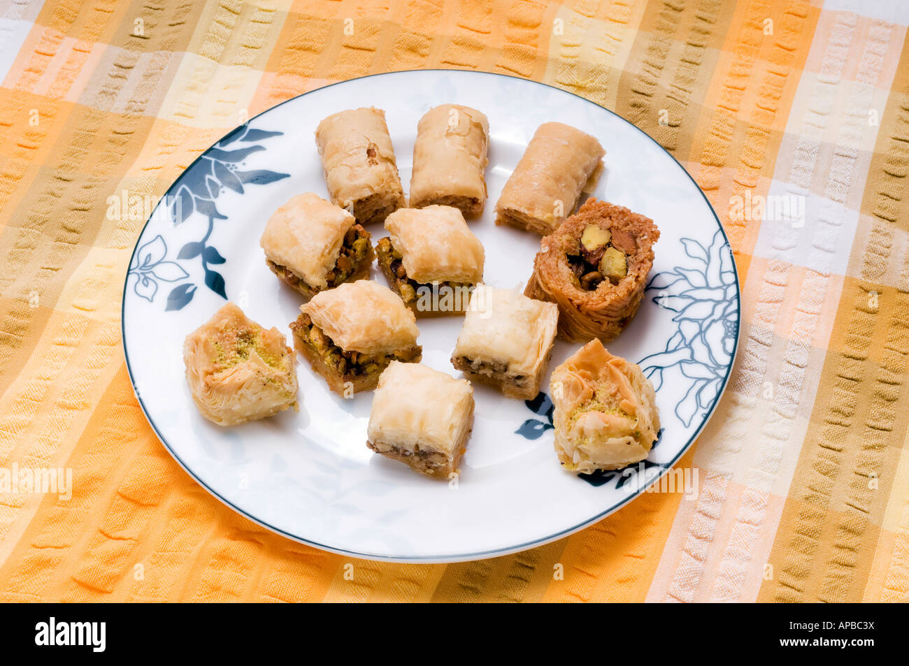 baklava on a blue patterned plate and yellow cotton seersucker  table cloth Stock Photo