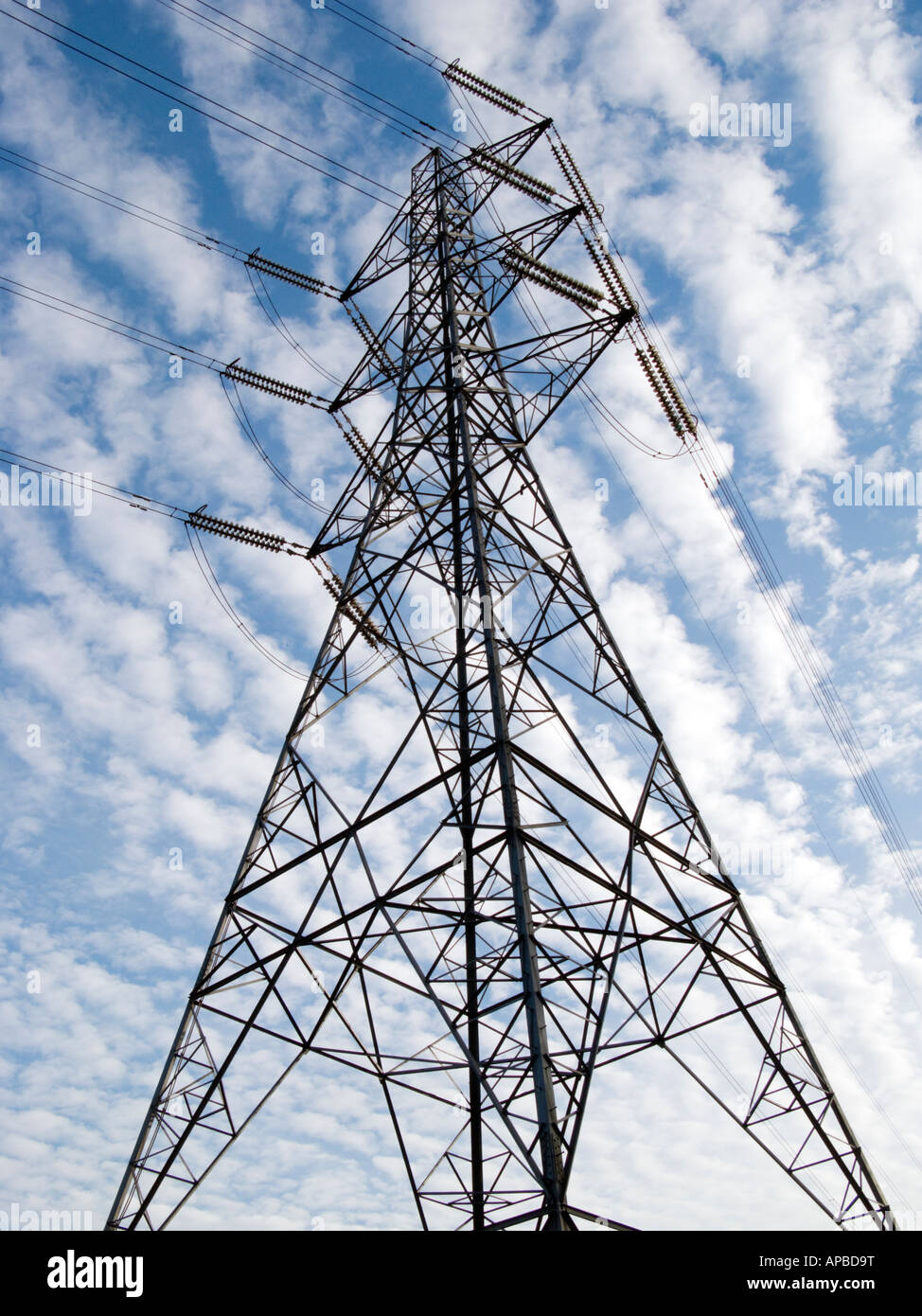 Electricity pylon against clouded blue sky Stock Photo - Alamy