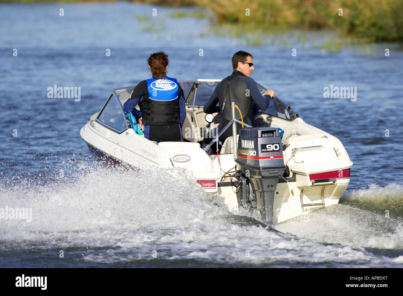 couple in wetsuits on a motor speed boat with yamaha 90 outboard
