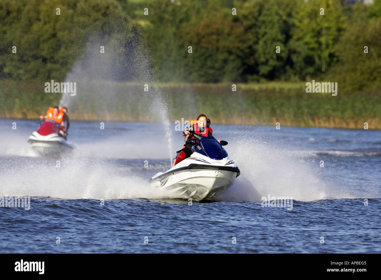 two yamaha waverunner jetskis one driven by young woman chasing each other along the river bann county antrim northern ireland Stock Photo