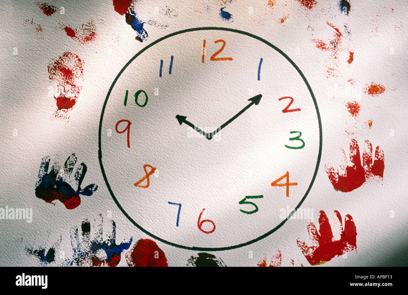 Child drawing of a clock face with hand and foot prints Stock Photo