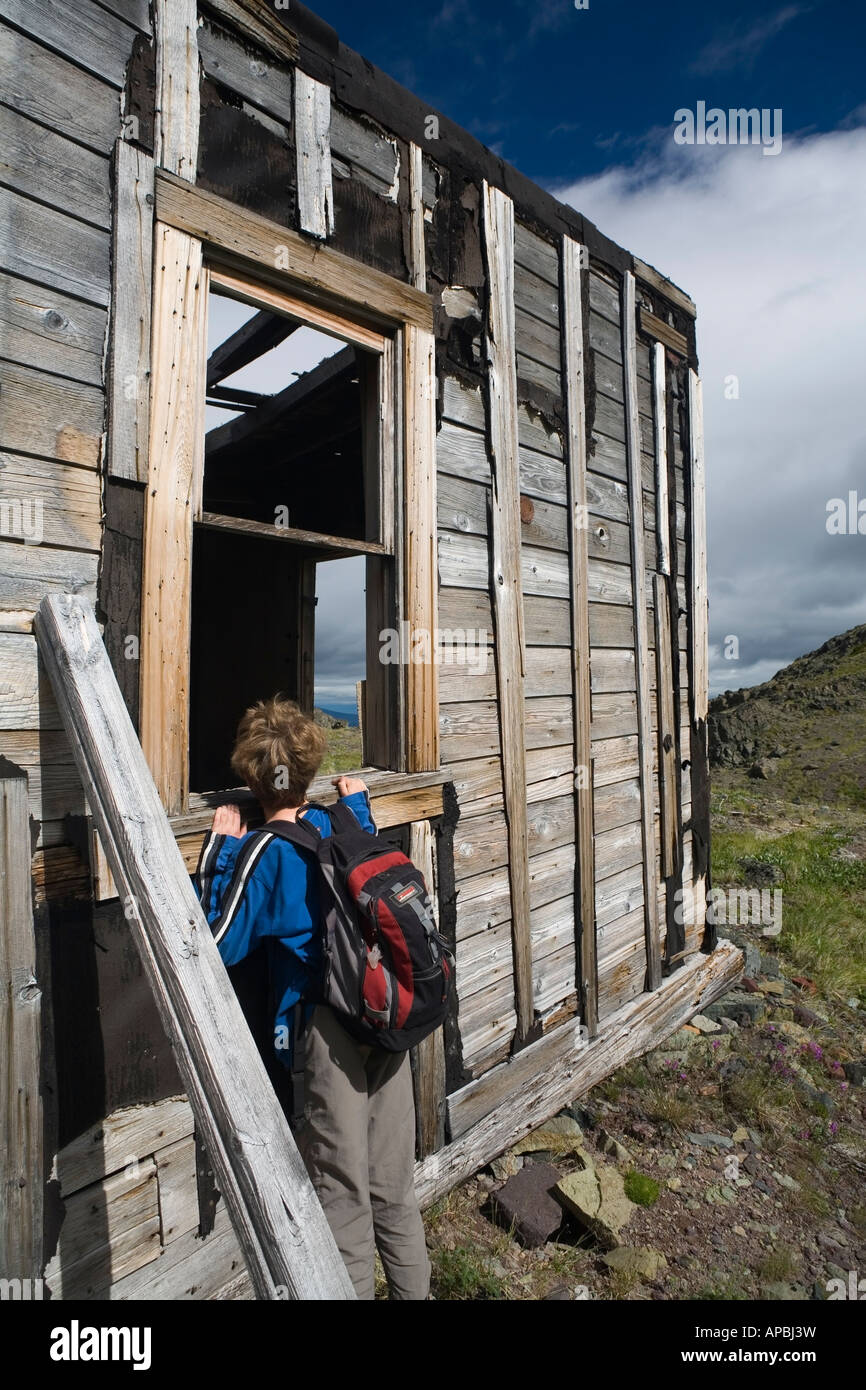 Hiker exploring old mine cabin Hunters Basin Telkwa Mountains BC Stock