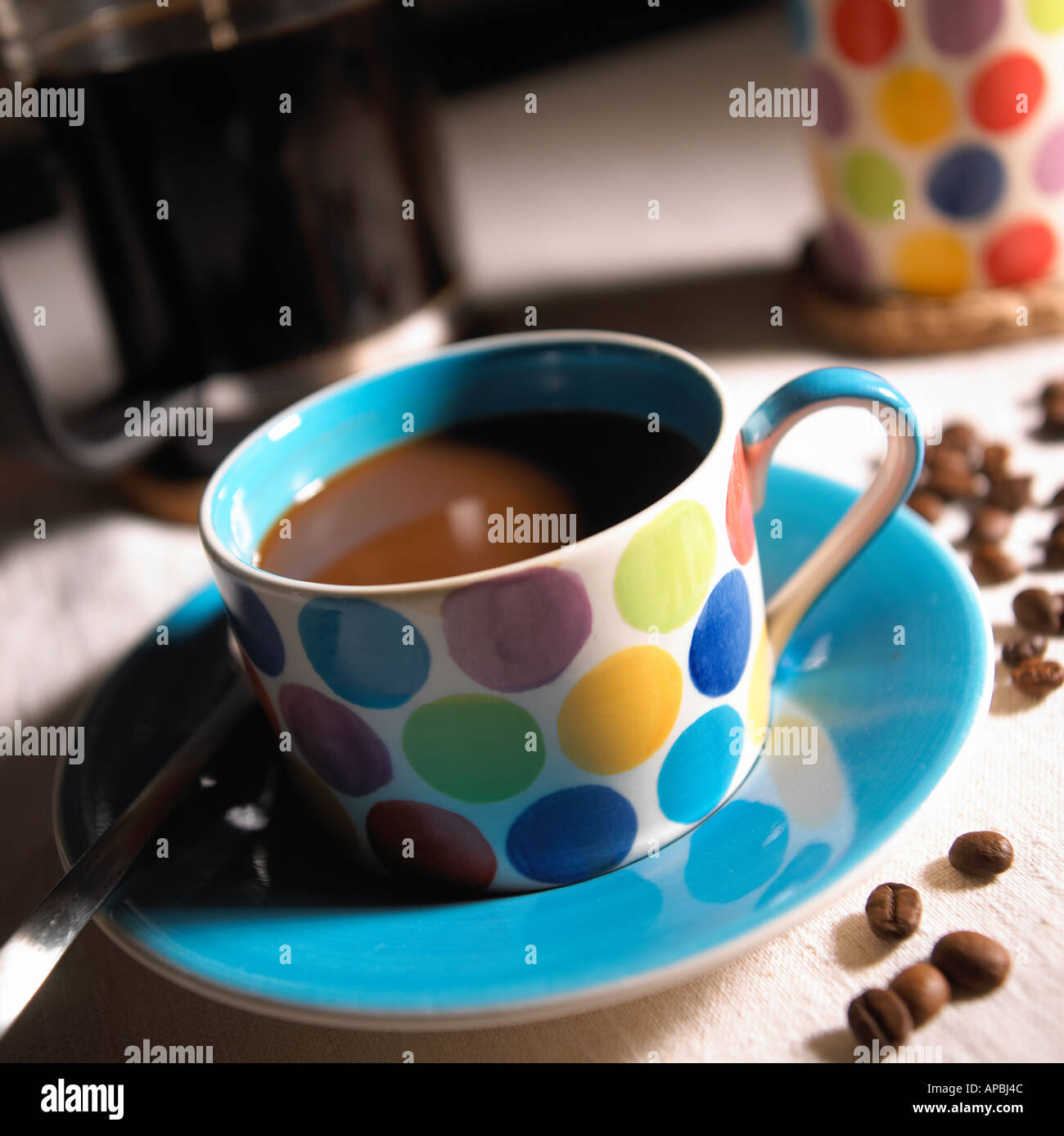 Spotted Coffee Cup with Beans and Cafetiere Stock Photo