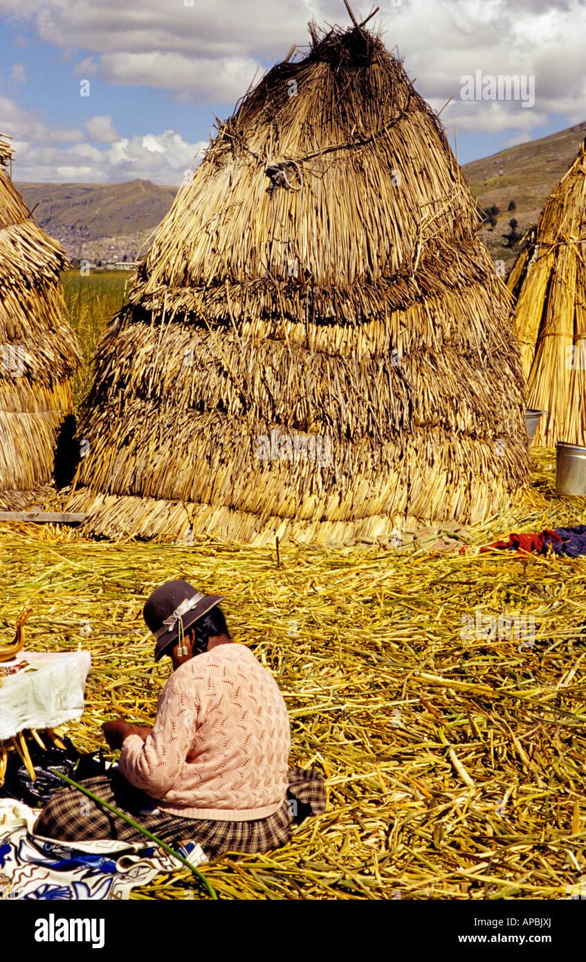 A local seller working on crafts beside traditional reed huts on the ...