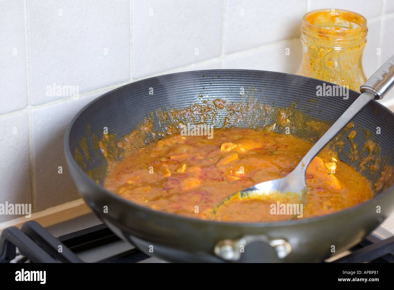 COOKING CHICKEN CURRY IN A WOK WITH READY PREPARED COOK IN SAUCE Stock  Photo - Alamy