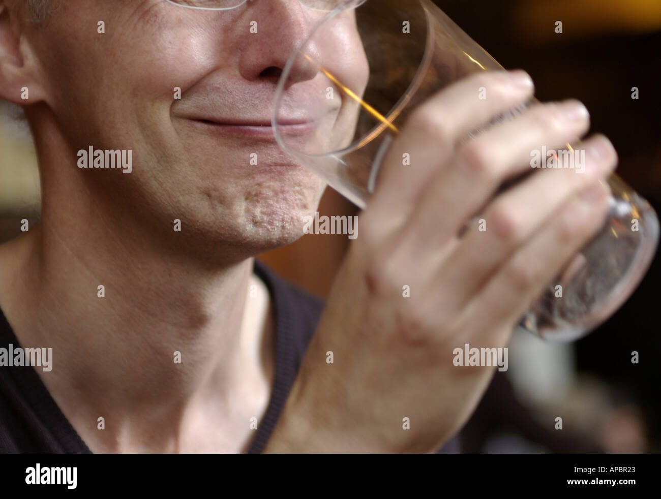 Man grinning as he finishes beer Stock Photo