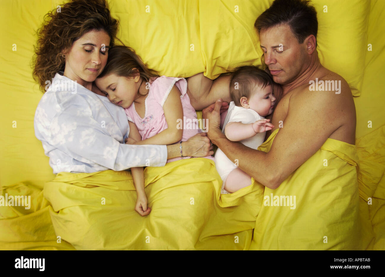Family lying in bed Stock Photo