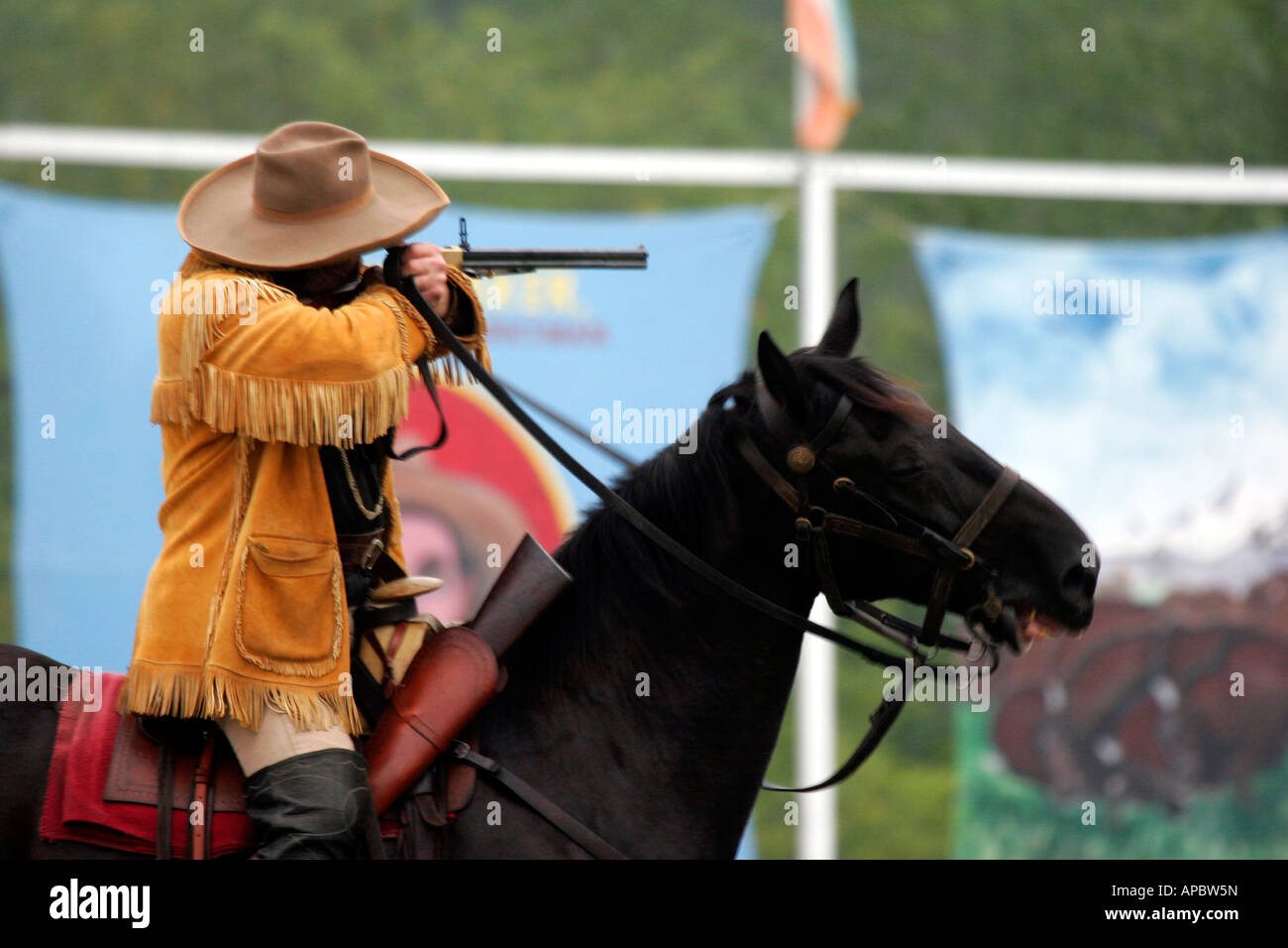 Buffalo Bill on Horseback shooting a rifle at a target at the Buffalo Bill Wild West Show Reenactment Stock Photo