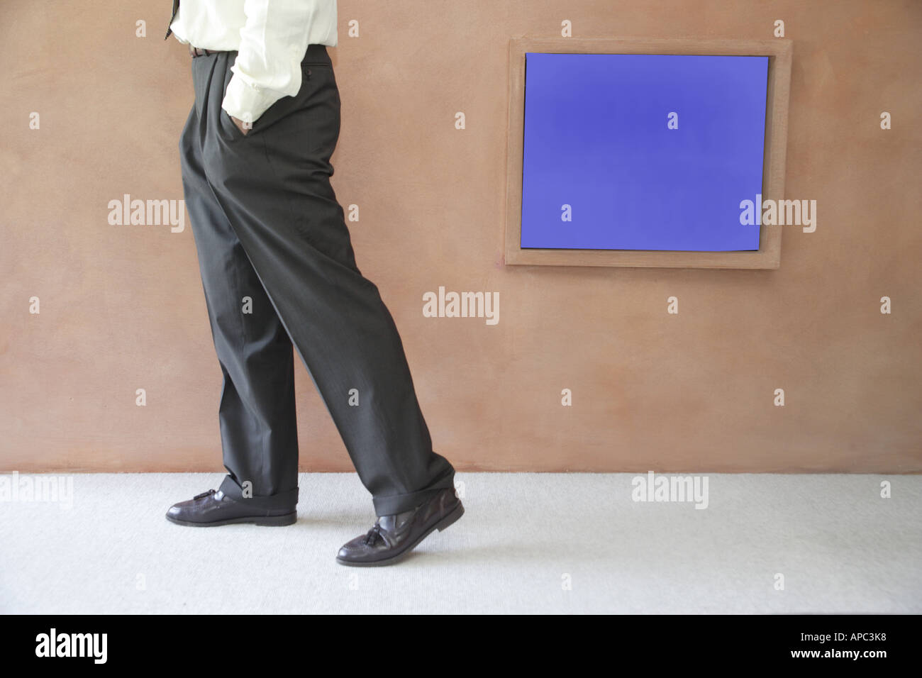 Legs of a businessman standing in front of a monitor Stock Photo