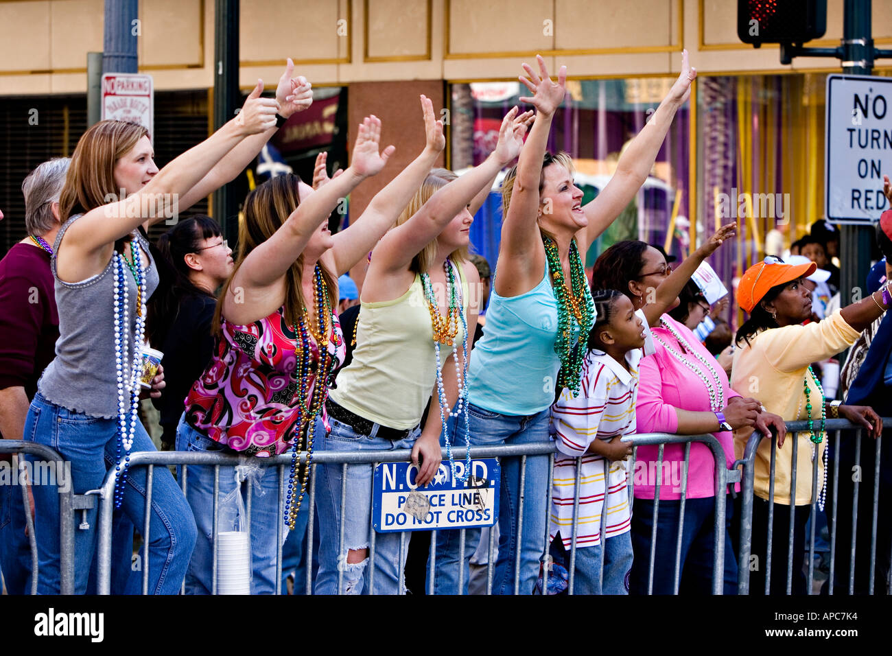 Girls reaching for beads during a mardi gras parade in New Orleans