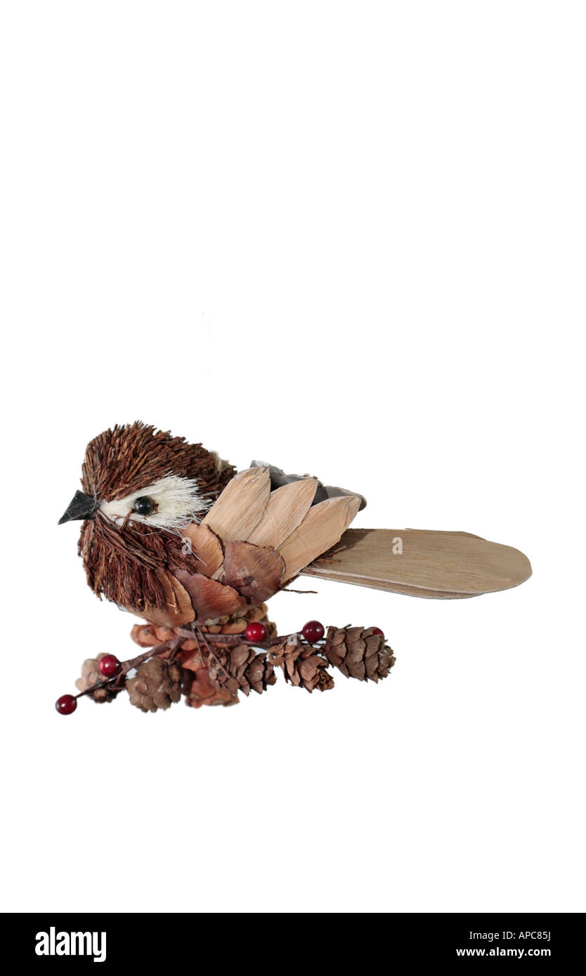 A cute little bird hanging Christmas tree decoration made out of natural materials such as wood, pine cones and berries Stock Photo