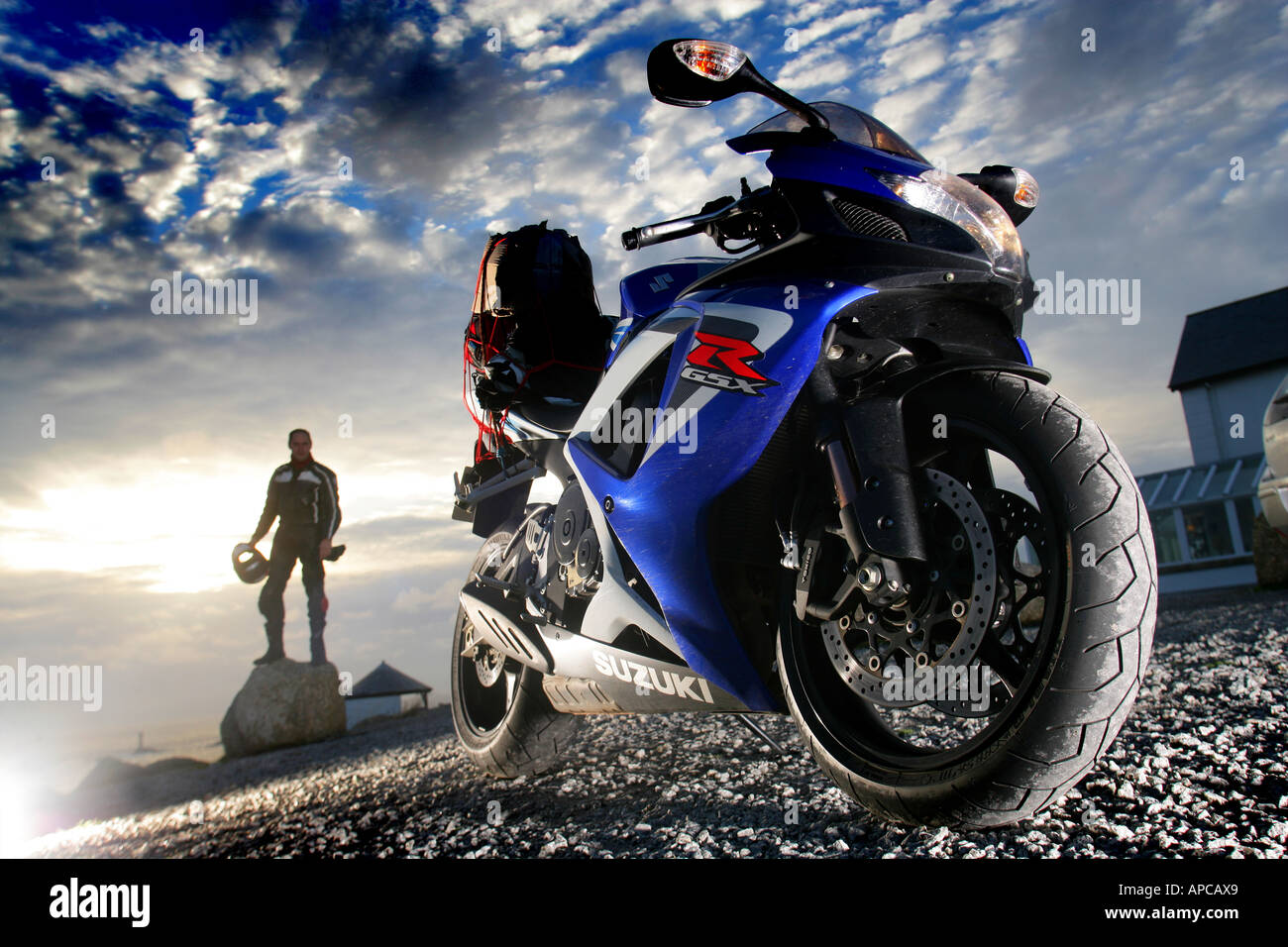 motorbike and rider at lands end cornwall with sunset Stock Photo