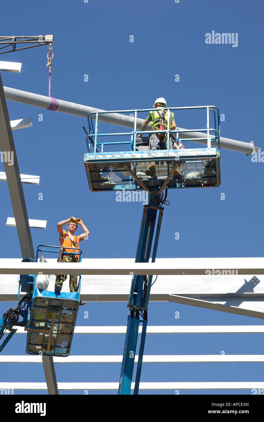 Steel erectors on two cherry pickers access platform during